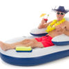 Senior man in beach hat and sunglasses enjoying a cold umbrella drink while sitting in a floating lounge.