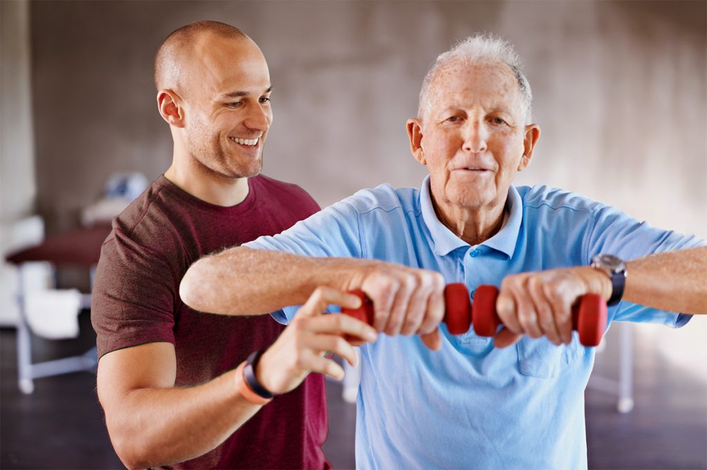 Physical Therapist with Senior Man lifting hand weights.