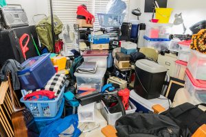 Hoarder room packed with stored boxes, electronics, files, business equipment and household items.