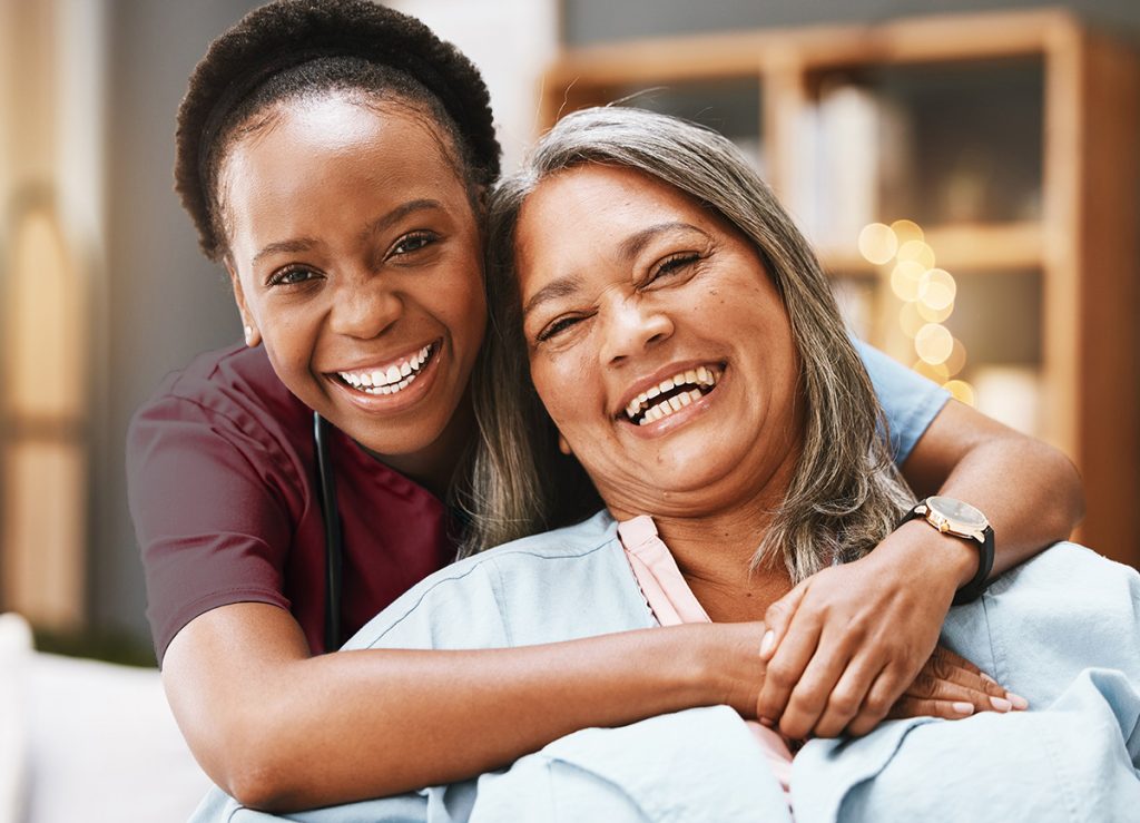 Nurse and patient smiling together at home.