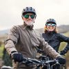 Smiling, happy senior man and woman in black leather going out on a bike hike.