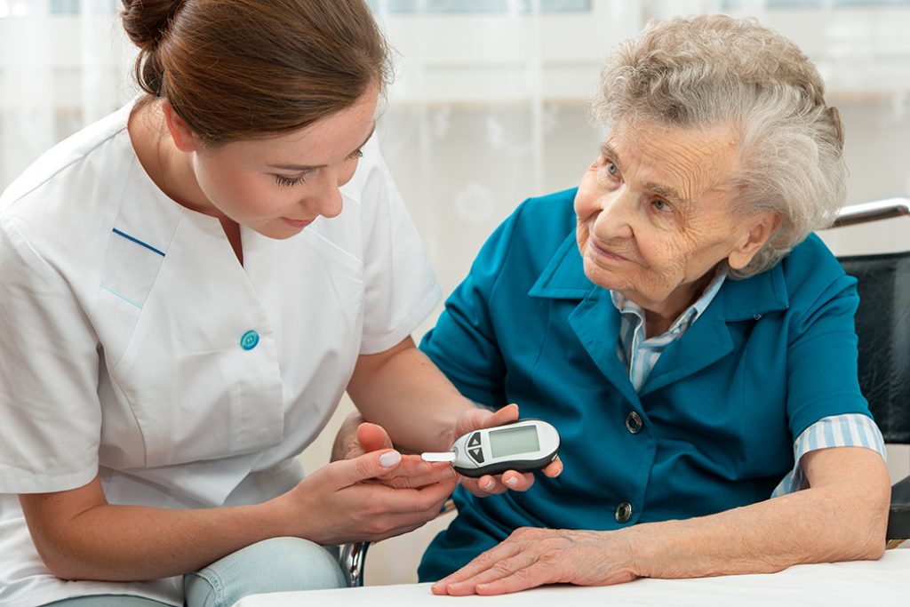 Nurse checking the blood sugar of a senior woman who looks concerned.