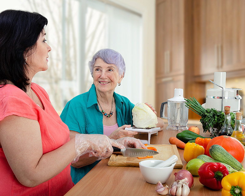 Caregiver and senior preparing a healthy meal. 