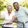 African American man and woman smiling while out riding bicycles.