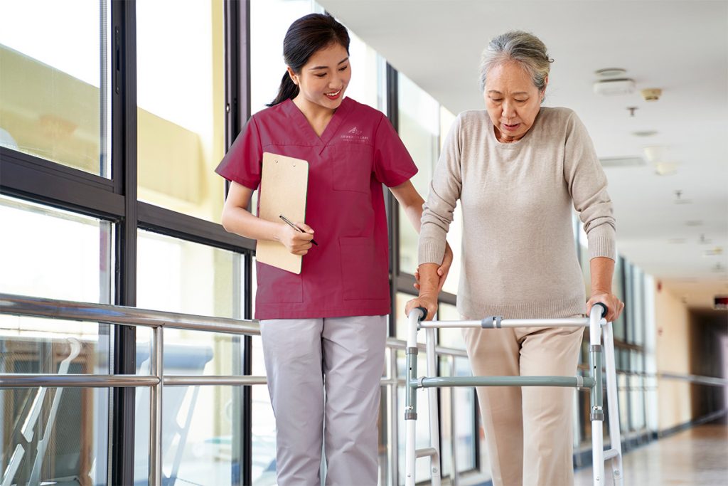Asian therapist works with Asian patient on proper walking.