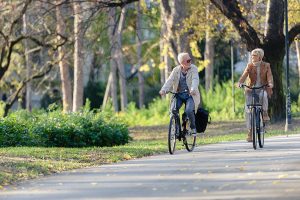 Senior man and senior woman riding bicycles on a sunny September morning
